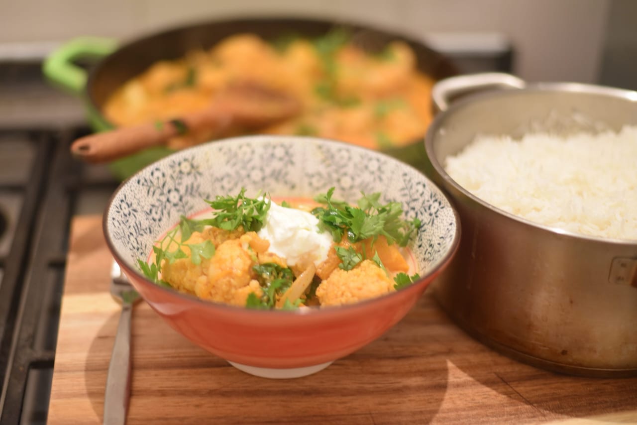 Set a bowl with rice and place the vindaloo sauce and vegetables over it. Add sour cream and fresh coriander and drizzle with olive oil. Serve immediately.