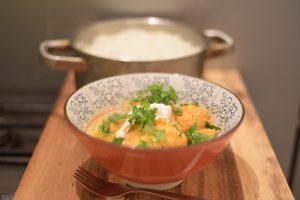 Set a bowl with rice and place the vindaloo sauce and vegetables over it. Add sour cream and fresh coriander and drizzle with olive oil. Serve immediately.